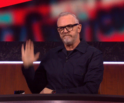 Man Waving Hand at Table