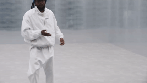 Man Waving in White Jacket and Pants
