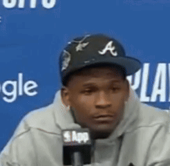 Man Wearing Baseball Cap Talking Into Microphone