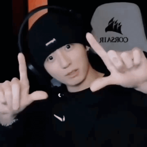 Man Wearing Black Hat and Headphones Making Peace Sign