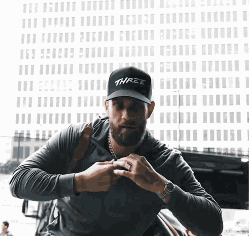 Man Wearing Black Hat Saying Three