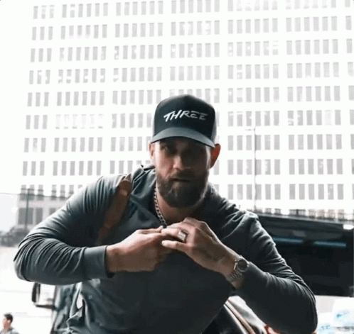 Man Wearing Black Hat Saying Three