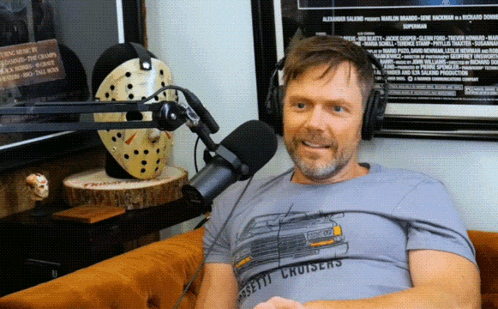 Man Wearing Cassette Cruisers T-Shirt Sitting at Microphone