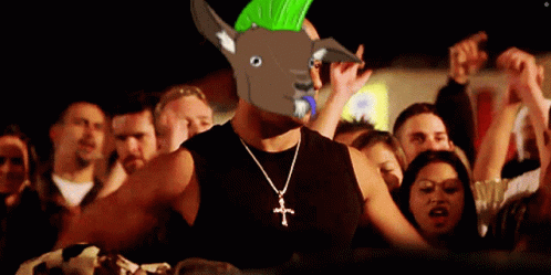 Man Wearing Cross Necklace and Mohawk Stands in Front of Crowd