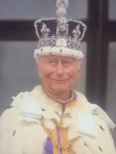 Man Wearing Crown and Purple Ribbon Smiling