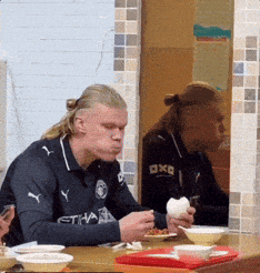 Man Wearing Etihad Shirt Eating