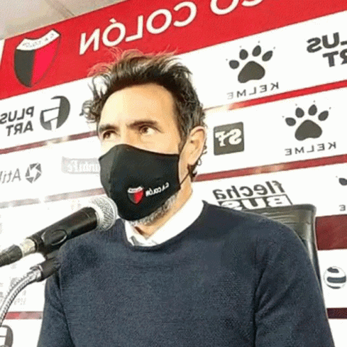 Man Wearing Face Mask at Microphone