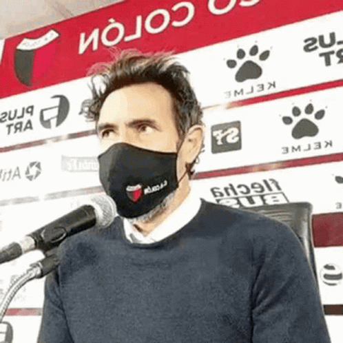 Man Wearing Face Mask Talking Into Microphone