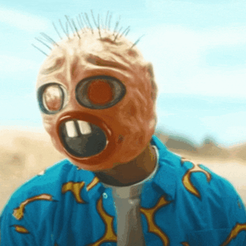 Man Wearing Gas Mask and Blue Shirt With Flames on Sleeves