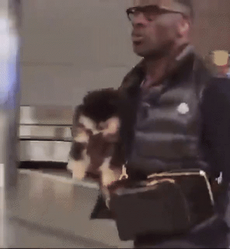Man Wearing Glasses And Black Vest Holding Purse GIF