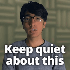 Man Wearing Glasses and Grey Shirt Says Keep Quiet