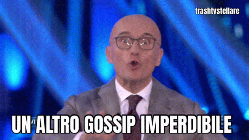 Man Wearing Glasses And Suit Says Un Altro Gossip Imperdibile GIF