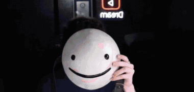 Man Wearing Glasses Holding Smiley Mask