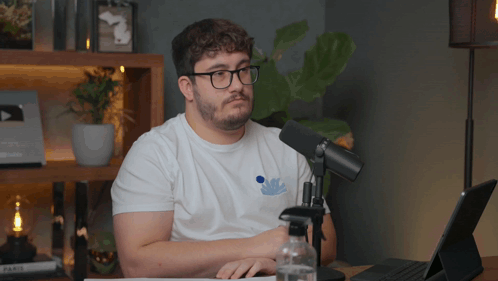 Man Wearing Glasses Sitting In Front Of Microphone GIF