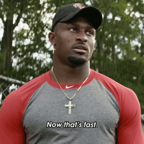 Man Wearing Hat and Cross Necklace Says Now That's Fast