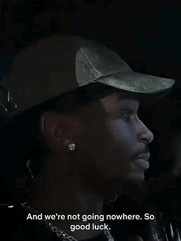 Man Wearing Hat and Earrings Saying Good Luck