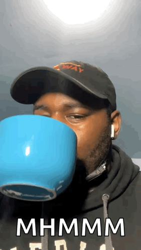 Man Wearing Hat and Headphones Drinking Mhm Mhm Cup
