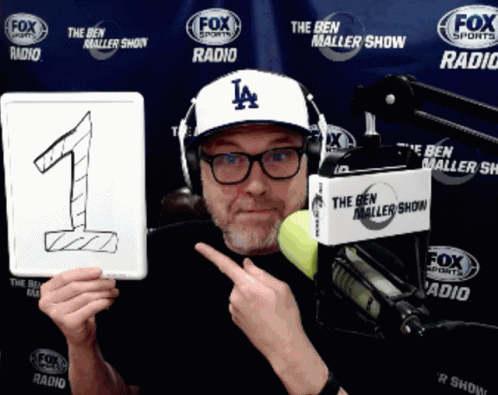 Man Wearing Hat Holding Number One Sign