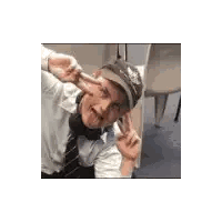 Man Wearing Headphones and Hat Giving Peace Sign