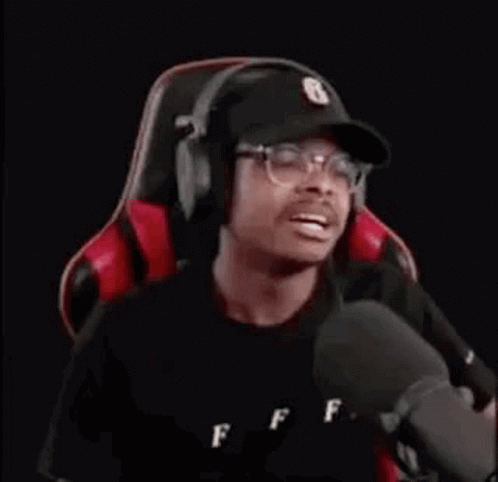 Man Wearing Headphones And Hat Sitting In Gaming Chair GIF