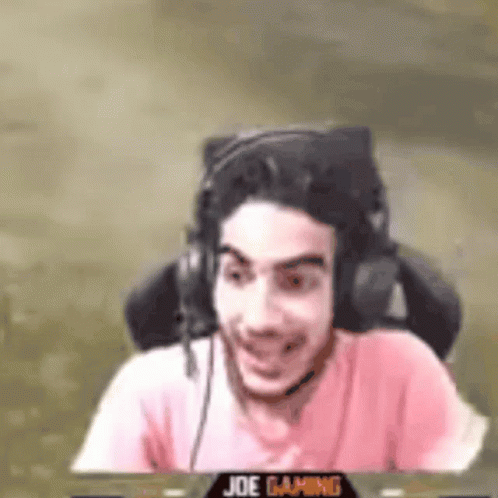 Man Wearing Headphones and Pink Shirt Sitting and Smiling