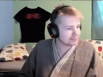 Man Wearing Headphones and Robe Sitting in Bedroom