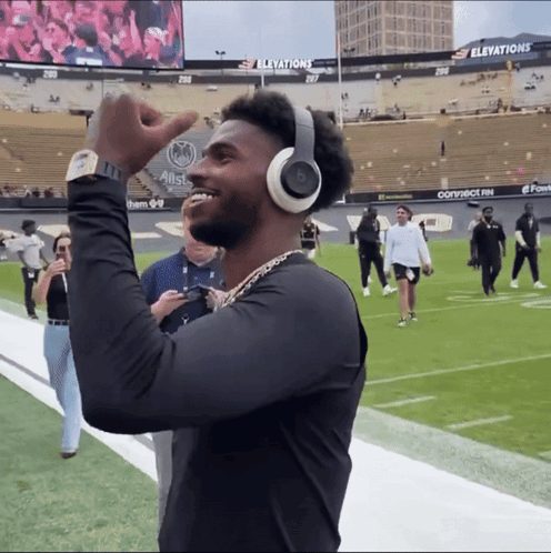 Man Wearing Headphones and Watch on Football Field