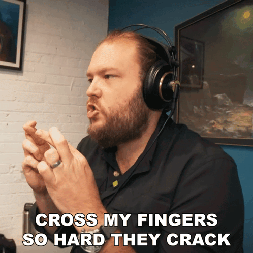 Man Wearing Headphones Crosses Fingers