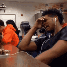 Man Wearing Headphones Crying in Classroom