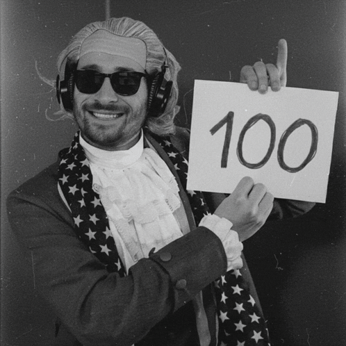 Man Wearing Headphones Holding Sign With 100 GIF