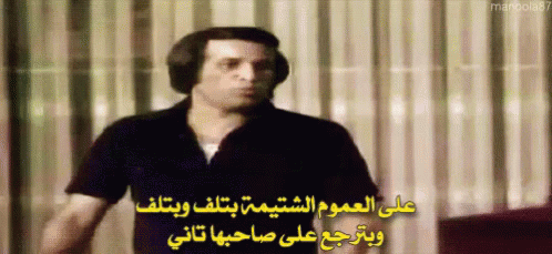 Man Wearing Headphones in Front of Curtain With Arabic Writing