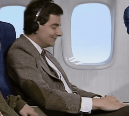 Man Wearing Headphones Looking Out Plane Window
