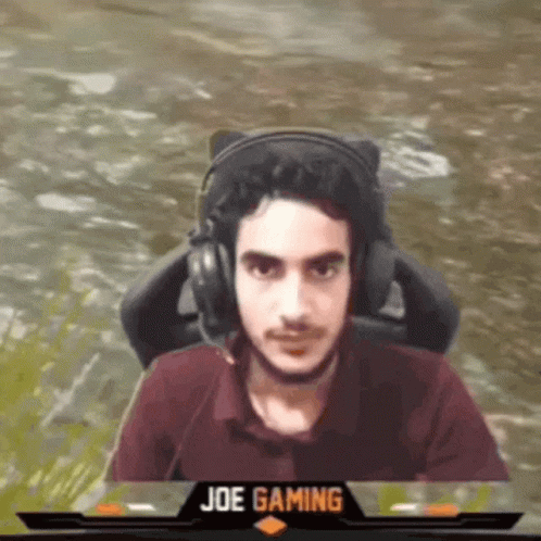 Man Wearing Headphones Sitting in Front of Joe Gaming Logo