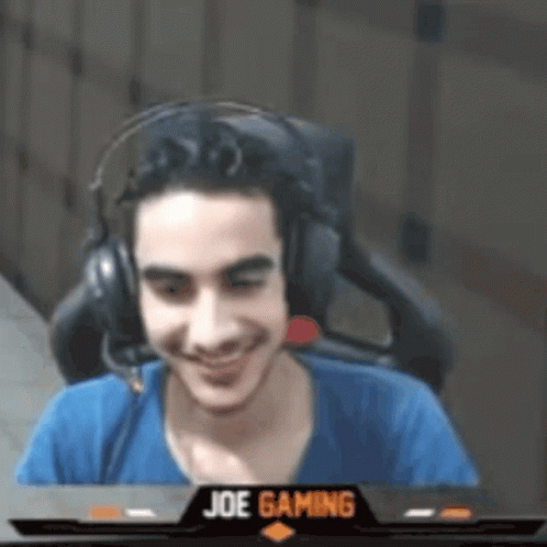 Man Wearing Headphones Sitting in Front of Screen Saying Joe Gaming