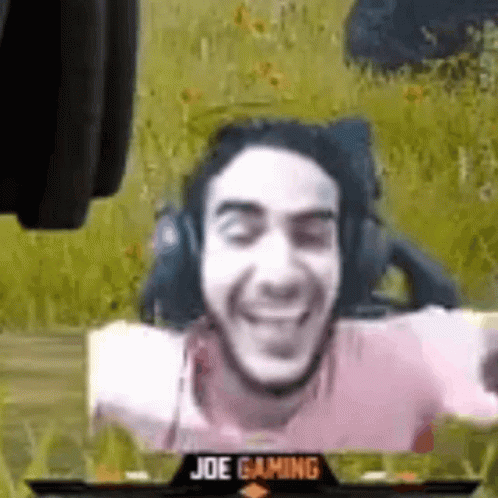 Man Wearing Headphones Sitting With Arms Outstretched Playing Video Game