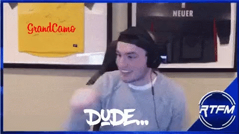 Man Wearing Headphones Smiling In Front Of Grandcamo Sign