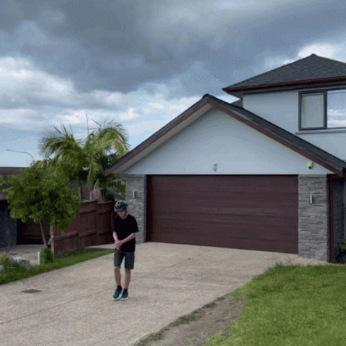 Man Wearing Helmet in Front of House