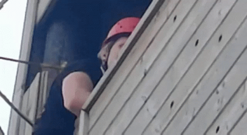 Man Wearing Helmet Looking Out Window