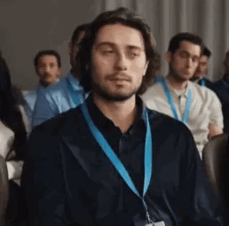 Man Wearing Lanyard Sitting in Room