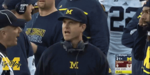 Man Wearing M Hat in Crowd