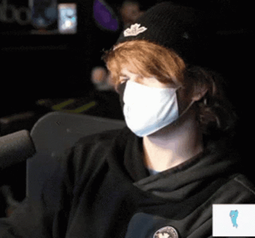 Man Wearing Mask And Hat Sitting At Microphone GIF
