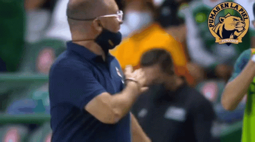 Man Wearing Mask Talking to Man with Puma Logo