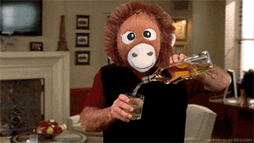 Man Wearing Stuffed Monkey Mask Pouring Liquor