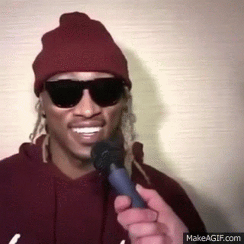 Man Wearing Sunglasses and Beanie Holding Microphone