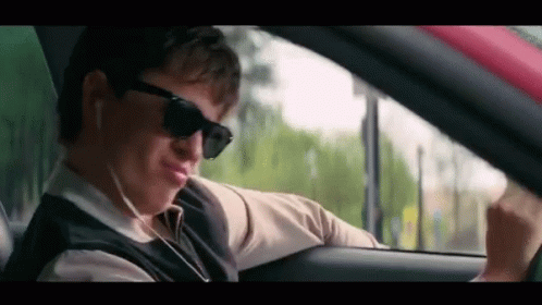 Man Wearing Sunglasses and Earphones Driving