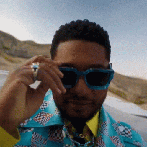 Man Wearing Sunglasses And Ring Looking At Camera GIF