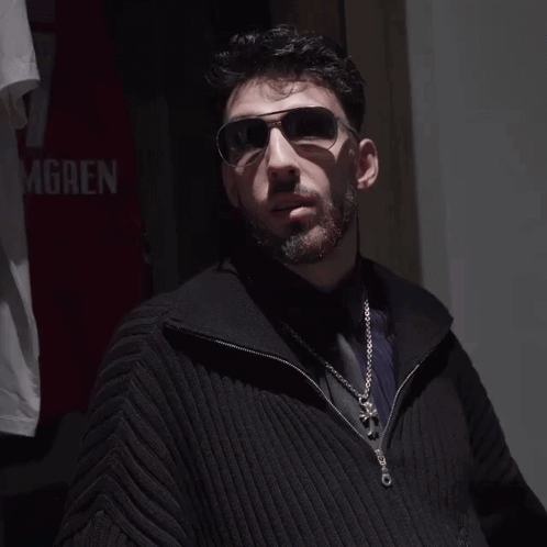 Man Wearing Sunglasses in Front of Gren Shirt
