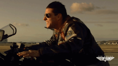 Man Wearing Sunglasses Riding Motorcycle With Top Gun Logo GIF