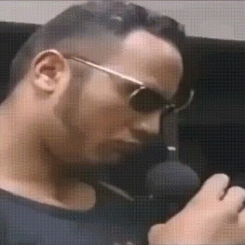 Man Wearing Sunglasses Talking Into Microphone GIF