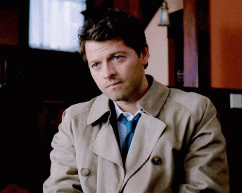 Man Wearing Trench Coat and Tie Sitting in Room